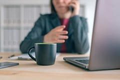 Businesswoman talking on mobile phone during coffee break from office stock photos Businesswoman talking on mobile phone during coffee break from office stock photos