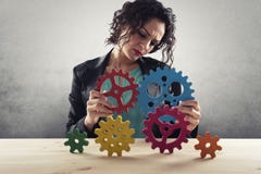 Businesswoman tries to connect gears pieces. Concept of Teamwork, partnership and integration stock image Businesswoman tries to connect gears pieces. Concept of Teamwork, partnership and integration stock image