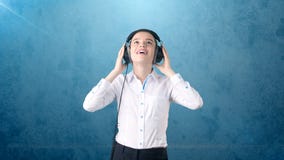 Businesswoman in white skirt relaxing listening to music on stereo headphones with blissful smile. Background isolated . Royalty Free Stock Images Businesswoman in white skirt relaxing listening to music on stereo headphones with blissful smile. Background isolated . Royalty Free Stock Images