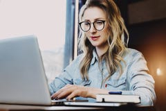 Businesswoman working on laptop. Smiling millennial girl uses computer while sitting in coffee shop.Online education royalty free stock photo Businesswoman working on laptop. Smiling millennial girl uses computer while sitting in coffee shop.Online education royalty free stock photo