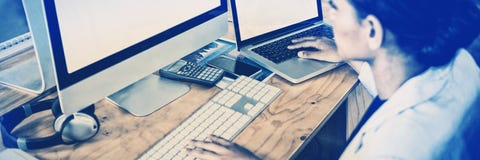 Businesswoman working over computer and laptop royalty free stock photo Businesswoman working over computer and laptop royalty free stock photo