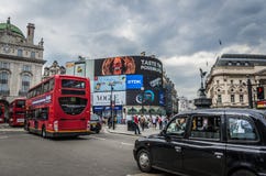 Bussen och taxin trafikerar på den Piccadilly cirkusen i London, England Arkivbilder Bussen och taxin trafikerar på den Piccadilly cirkusen i London, England Arkivbilder