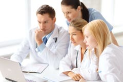Busy group of doctors looking at laptop computer