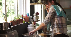 Busy Woman In Kitchen Cooking Meal And Talking On Phone
