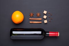 Butelka czerwone wino i pikantność dla rozmyślającego wina na czarnym tle Cynamon, anyżowe gwiazdy, pomarańcze, brown cukier fotografia royalty free Butelka czerwone wino i pikantność dla rozmyślającego wina na czarnym tle Cynamon, anyżowe gwiazdy, pomarańcze, brown cukier fotografia royalty free