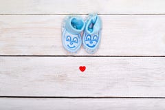 Butins bleus pour le garçon et un petit coeur rouge sur un blanc en bois images libres de droits Butins bleus pour le garçon et un petit coeur rouge sur un blanc en bois images libres de droits
