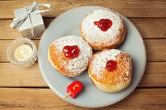 Buñuelos con el atasco para el día de fiesta judío Jánuca sobre fondo de madera fotografía de archivo libre de regalías Buñuelos con el atasco para el día de fiesta judío Jánuca sobre fondo de madera fotografía de archivo libre de regalías