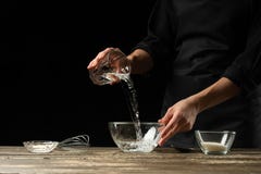Bäcker, der Hefeteig, auf einem dunklen Hintergrund zubereitet Bäckereikonzept- und -teigvorbereitung lizenzfreies stockfoto Bäcker, der Hefeteig, auf einem dunklen Hintergrund zubereitet Bäckereikonzept- und -teigvorbereitung lizenzfreies stockfoto