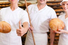Bäcker mit seinem Team in der Bäckerei lizenzfreie stockfotos Bäcker mit seinem Team in der Bäckerei lizenzfreie stockfotos
