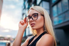 Bärande exponeringsglas för ung blond affärskvinna vid affärsmitten i stad guld- modell för klänningmode Formell stil arkivbilder Bärande exponeringsglas för ung blond affärskvinna vid affärsmitten i stad guld- modell för klänningmode Formell stil arkivbilder