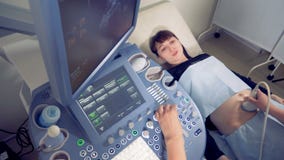 Bästa sikt av en ung gravid kvinna som genomgår ultraljudet lager videofilmer Bästa sikt av en ung gravid kvinna som genomgår ultraljudet lager videofilmer