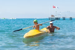 Bébé garçon de sourire de grand-père et de petit-fils petit dans la casquette de baseball verte kayaking à la mer tropicale d'océ photos stock Bébé garçon de sourire de grand-père et de petit-fils petit dans la casquette de baseball verte kayaking à la mer tropicale d'océ photos stock