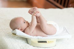 Bébé nouveau-né sur la balance photographie stock Bébé nouveau-né sur la balance photographie stock