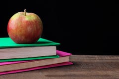 Bücher und ein Apfel auf einem Holztisch auf einem schwarzen Hintergrund Konzept der Ausbildung stockfotos Bücher und ein Apfel auf einem Holztisch auf einem schwarzen Hintergrund Konzept der Ausbildung stockfotos