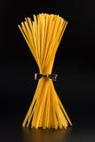 Bündel Spaghettis, die aufrecht auf einem hellen schwarzen Hintergrund stehen vertikal stockfotografie Bündel Spaghettis, die aufrecht auf einem hellen schwarzen Hintergrund stehen vertikal stockfotografie