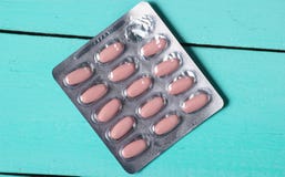 Bąbel różowe pigułki na błękitnym drewnianym tle zdjęcia stock Bąbel różowe pigułki na błękitnym drewnianym tle zdjęcia stock