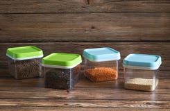 C?r?ales dans des r?cipients en plastique sur une table en bois photos libres de droits C?r?ales dans des r?cipients en plastique sur une table en bois photos libres de droits