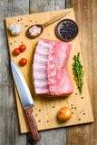 Côtelette de porc et ingrédients de cuisson sur la planche à découper en bois Image stock Côtelette de porc et ingrédients de cuisson sur la planche à découper en bois Image stock