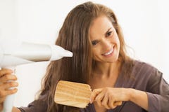 Cabelo de escovadela e secando da mulher no banheiro imagem de stock Cabelo de escovadela e secando da mulher no banheiro imagem de stock