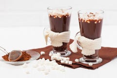 Cacao caliente en vidrios con las servilletas de la melcocha, de las decoraciones del crocahet, marrones y beige en el fondo de m Imagenes de archivo Cacao caliente en vidrios con las servilletas de la melcocha, de las decoraciones del crocahet, marrones y beige en el fondo de m Imagenes de archivo