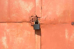 Cadeado em uma porta alaranjada velha da garagem fotografia de stock Cadeado em uma porta alaranjada velha da garagem fotografia de stock
