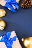 Cadeau avec le ruban bleu et arc-noeud, cône de sapin, boules de Noël, neige sur un fond bleu Copiez l'espace photos stock Cadeau avec le ruban bleu et arc-noeud, cône de sapin, boules de Noël, neige sur un fond bleu Copiez l'espace photos stock