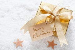 Cadeau d'or avec l'étiquette de Joyeux Noël image libre de droits Cadeau d'or avec l'étiquette de Joyeux Noël image libre de droits
