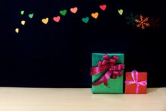 Cadeaux de Noël avec le bokeh de coeur et de neige sur la table en bois images stock Cadeaux de Noël avec le bokeh de coeur et de neige sur la table en bois images stock