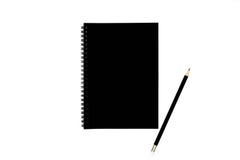 Caderno espiral preto com o lápis preto, isolado no fundo branco imagens de stock royalty free Caderno espiral preto com o lápis preto, isolado no fundo branco imagens de stock royalty free