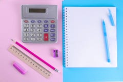 Cadernos e uma calculadora com artigos de papelaria diferentes em um fundo alaranjado e verde brilhante Fontes de escola fotos de stock Cadernos e uma calculadora com artigos de papelaria diferentes em um fundo alaranjado e verde brilhante Fontes de escola fotos de stock