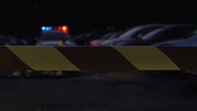Cadáver de examen del oficial de policía de la víctima en la escena del crimen rodeada con la cinta metrajes Cadáver de examen del oficial de policía de la víctima en la escena del crimen rodeada con la cinta metrajes