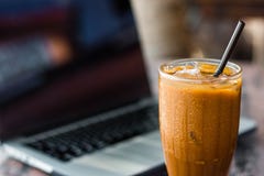 Caf? de glace dans une tasse avec un ordinateur portable sur le fond Concept et travail d'ind?pendant sur l'id?e de vacances image libre de droits Caf? de glace dans une tasse avec un ordinateur portable sur le fond Concept et travail d'ind?pendant sur l'id?e de vacances image libre de droits
