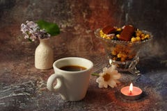 Caf? de matin press? : une tasse de caf?, de fleurs dans un vase, de fruits secs et de bonbons dans un vase, une bougie br?lante photographie stock Caf? de matin press? : une tasse de caf?, de fleurs dans un vase, de fruits secs et de bonbons dans un vase, une bougie br?lante photographie stock