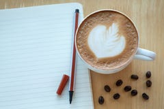 Caffè di arte del Latte e chicchi di caffè arrostiti con papernote al mattino Fotografie Stock Libere da Diritti Caffè di arte del Latte e chicchi di caffè arrostiti con papernote al mattino Fotografie Stock Libere da Diritti