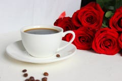 Caffè e rose, natura morta Caffè nero in una tazza bianca con un piattino sulla tavola, un mazzo delle rose rosse immagini stock libere da diritti Caffè e rose, natura morta Caffè nero in una tazza bianca con un piattino sulla tavola, un mazzo delle rose rosse immagini stock libere da diritti