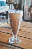 Caffè ghiacciato con latte che si siede sulla Tabella fotografia stock libera da diritti Caffè ghiacciato con latte che si siede sulla Tabella fotografia stock libera da diritti