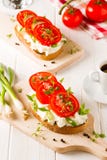 Café da manhã fresco da mola com pão brindado com queijo e tomates Fotografia de Stock Café da manhã fresco da mola com pão brindado com queijo e tomates Fotografia de Stock