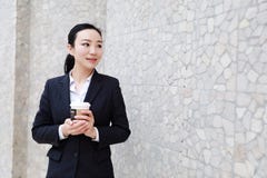 Café de consumición que camina de la mujer de negocios imágenes de archivo libres de regalías Café de consumición que camina de la mujer de negocios imágenes de archivo libres de regalías