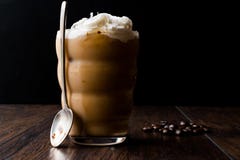 Café froid avec de la crème et lait fouetté, cuillère et grains de café photographie stock libre de droits Café froid avec de la crème et lait fouetté, cuillère et grains de café photographie stock libre de droits
