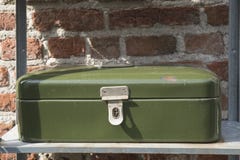 Caixa verde do metal do vintage para o pão ou o dinheiro, na prateleira do ferro, contra a parede de tijolo imagem de stock Caixa verde do metal do vintage para o pão ou o dinheiro, na prateleira do ferro, contra a parede de tijolo imagem de stock