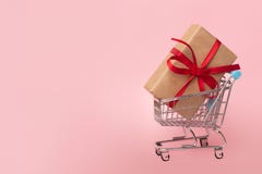 Caja de regalo en un carro de la compra en fondo rosado Concepto para las compras Copie el espacio foto de archivo libre de regalías Caja de regalo en un carro de la compra en fondo rosado Concepto para las compras Copie el espacio foto de archivo libre de regalías