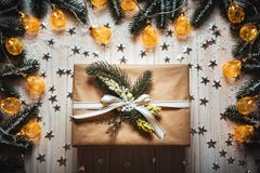 Caja de regalo de la Navidad con un arco y una guirnalda que brilla intensamente hermosa contra el fondo de madera blanco con las foto de archivo Caja de regalo de la Navidad con un arco y una guirnalda que brilla intensamente hermosa contra el fondo de madera blanco con las foto de archivo