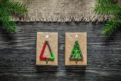 Caja de regalo de la Navidad de la rama del pino de la arpillera del vintage en el tablero de madera imagenes de archivo Caja de regalo de la Navidad de la rama del pino de la arpillera del vintage en el tablero de madera imagenes de archivo