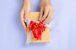 Caja de regalo de oro adornada con la cinta roja, actual embalaje para el soldado enrollado en el ejército Imagen de archivo Caja de regalo de oro adornada con la cinta roja, actual embalaje para el soldado enrollado en el ejército Imagen de archivo