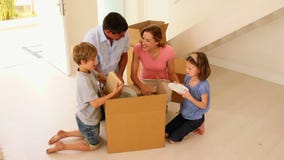 Caja feliz de la abertura de la familia en su nuevo hogar metrajes Caja feliz de la abertura de la familia en su nuevo hogar metrajes