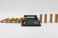 Calculator stopping a line of dominoes from falling. royalty free stock photos Calculator stopping a line of dominoes from falling. royalty free stock photos