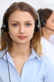 Call center operators. Focus at young beautiful business woman in headset stock images Call center operators. Focus at young beautiful business woman in headset stock images