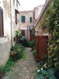 Calle estrecha y vieja de una pequeña ciudad en Italia fotografía de archivo Calle estrecha y vieja de una pequeña ciudad en Italia fotografía de archivo