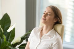 Calm attractive woman feeling relaxed leaning back on office cha