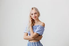 Calm and friendly beautiful blonde girl in summer outfit is smiling posing at camera, over white background. Emotions stock image Calm and friendly beautiful blonde girl in summer outfit is smiling posing at camera, over white background. Emotions stock image